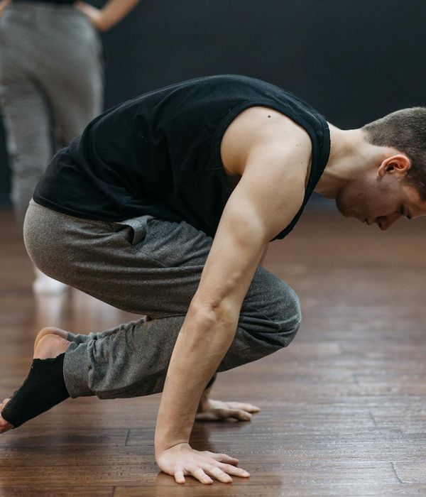 Man in a controlled strength pose showing balance and focus.
